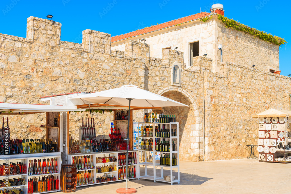 PRIMOSTEN, CROATIA - SEP 5, 2017: market stands with local handmade souvenirs in front of old town gate in Primosten, Dalmatia, Croatia.