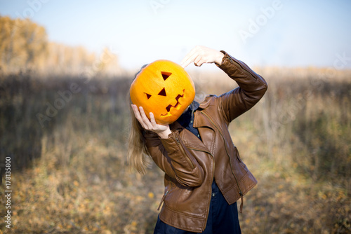 Girl holding a pumpkin instead of a head. The concept of holidays. Preparing for Halloween. Harvest. Head-pumpkin.