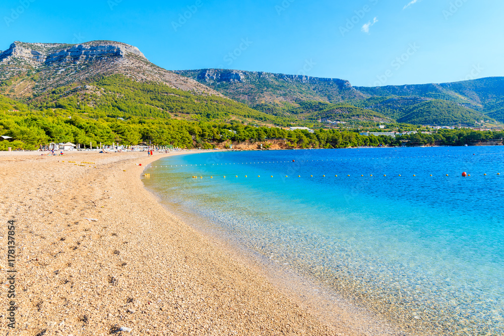 View of empty Zlatni Rat beach with beautiful sea water and mountains in background, Brac island, Croatia