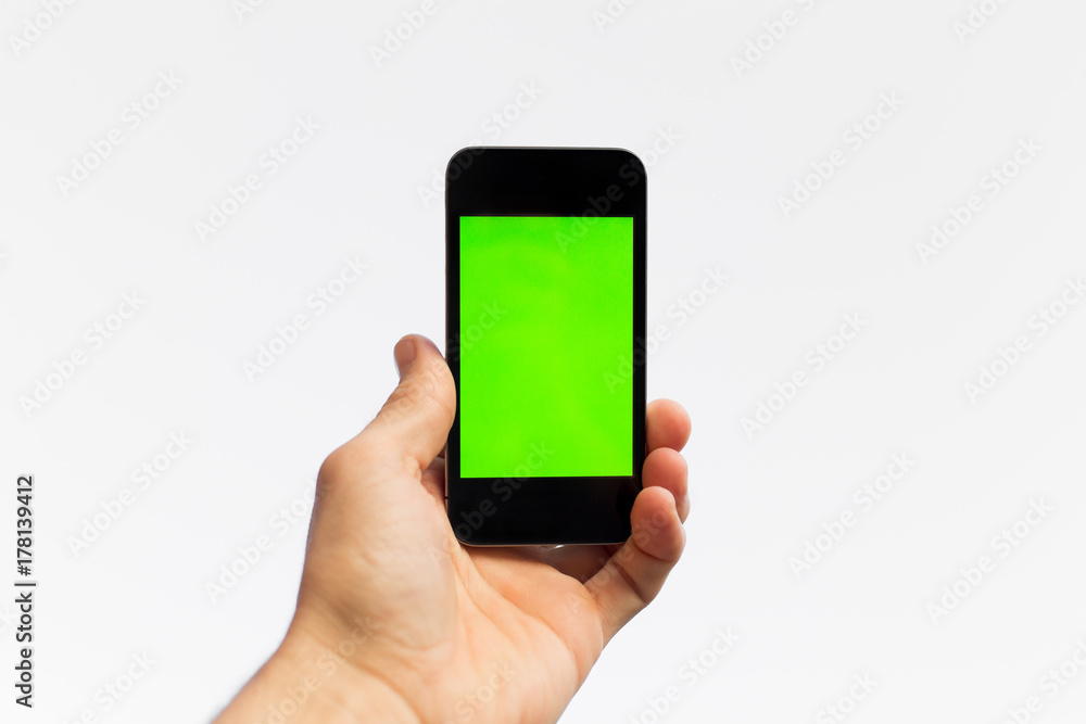 Man's hand shows mobile smartphone with green screen in horizontal position isolated on white background - mockup template and clipping path Man's hand shows mobile smartphone with green screen in horizontal position isolated on white background - mockup template and clipping path
