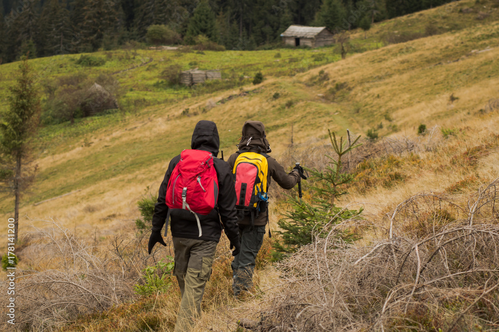 Young couple walking on the mountains road in autumn time Young couple walking on the mountains road in autumn time