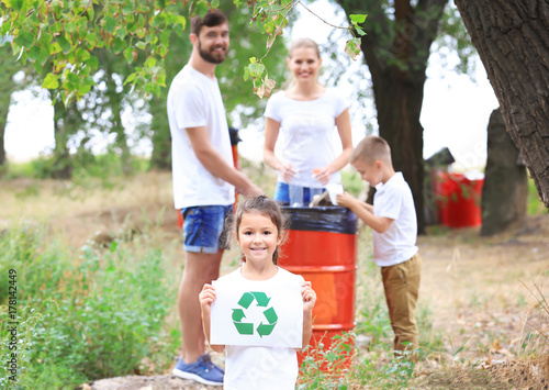 Family throwing garbage into litter bin outdoors. Recycling concept