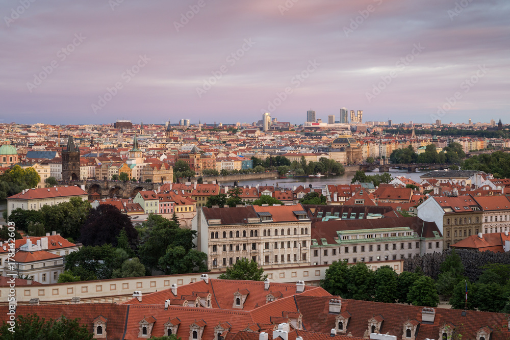 View of buildings at Mala Strana (Lesser Town), Old Town and beyond in Prague, Czech Republic, viewed slightly from above at sunset.