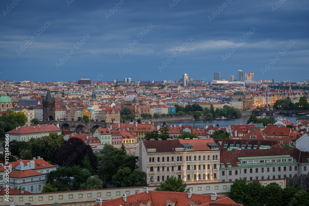 View of buildings at Mala Strana (Lesser Town), Old Town and beyond in Prague, Czech Republic, viewed slightly from above at dusk.