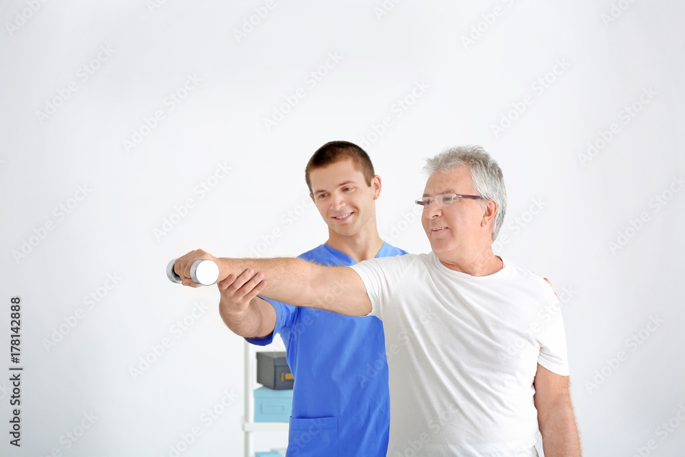 Physiotherapist working with senior patient in modern clinic Physiotherapist working with senior patient in modern clinic