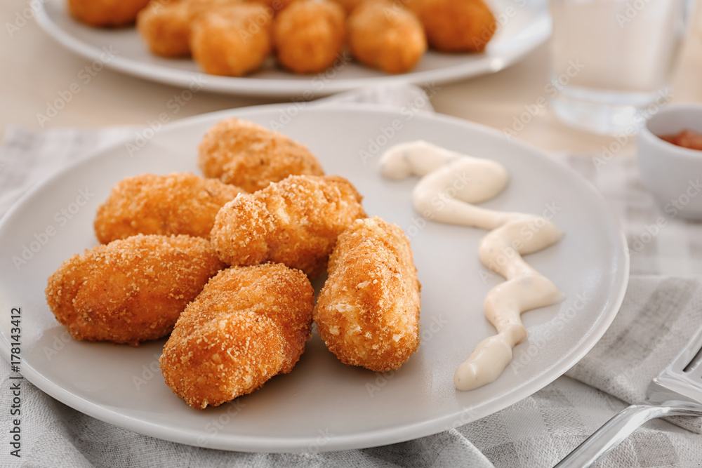 Plate with delicious salmon croquettes on table