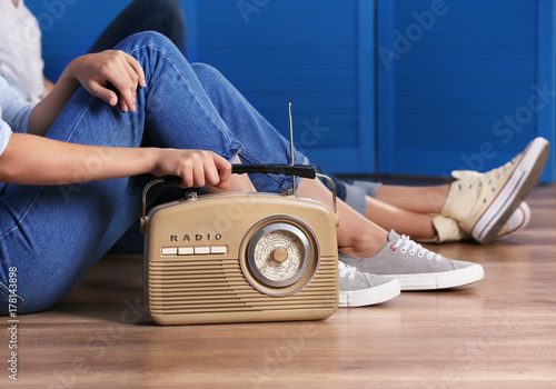 Fotografie Group of young women with retro radio indoors