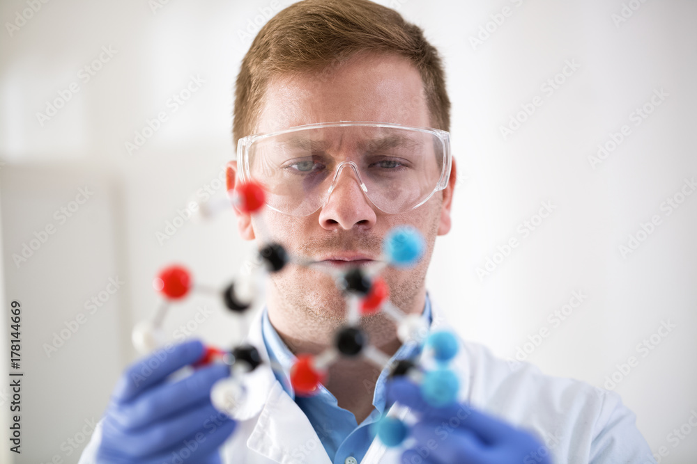 Young scientist holding molecular model at private clinic Young scientist holding molecular model at private clinic