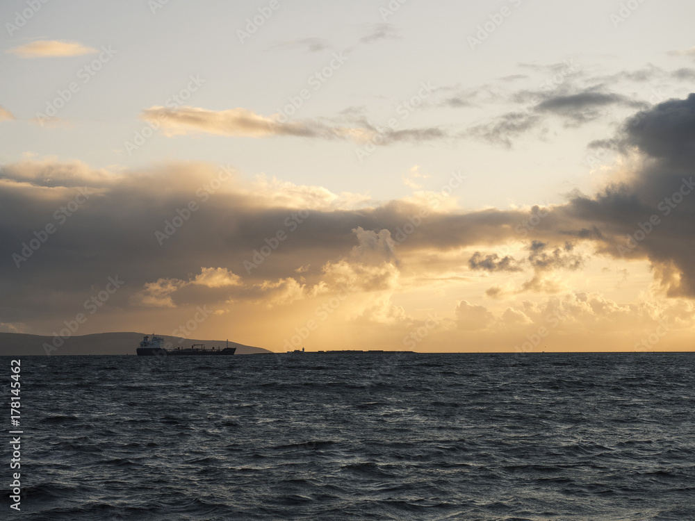 Cargo transport ship in the the Atlantic ocean at sunset, Cargo transport ship in the the Atlantic ocean at sunset,