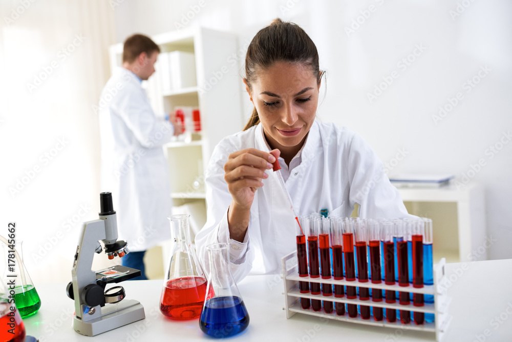 Scientists at laboratory researching sample of chemical Scientists at laboratory researching sample of chemical