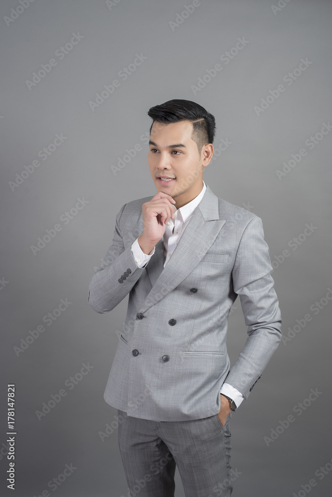 Businessman is thinking, portrait in studio grey background Businessman is thinking, portrait in studio grey background
