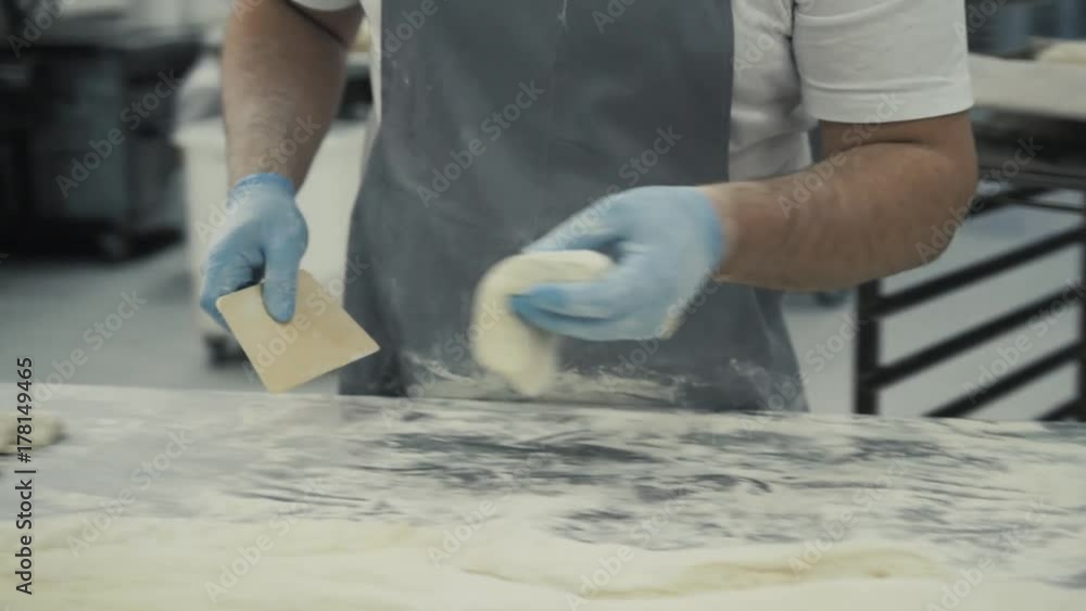 Male baker prepares bread. Male baker slaps on dough. Making bread. Cafe chef prepare croissaints Male baker prepares bread. Male baker slaps on dough. Making bread. Cafe chef prepare croissaints