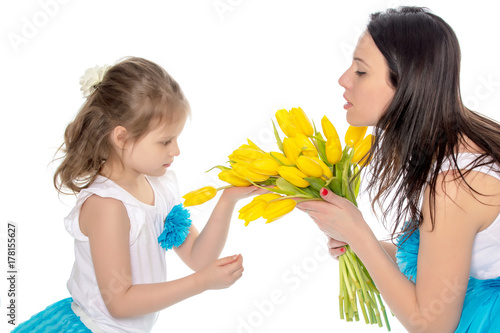 Mom and daughter enjoying the fragrance of flowers.