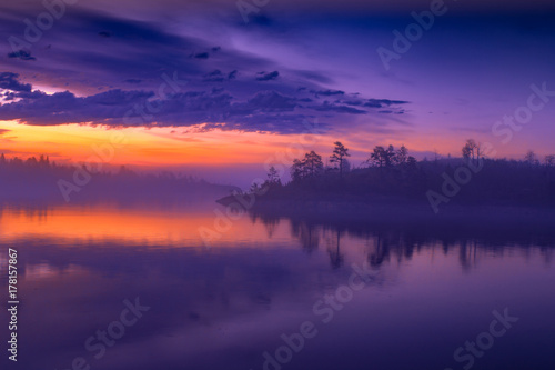 Fog over the lake. Beautiful sunset over the water. Clouds in the fog over the water.