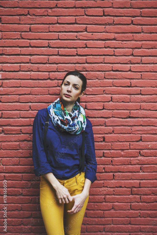 Beautiful woman standing in front red brick wall. Looking at camera. Beautiful woman standing in front red brick wall. Looking at camera.