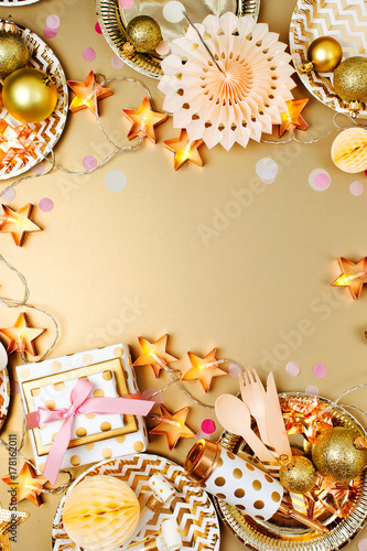 Christmas table setting. Frame made of golden party decoration stuff. Flat lay, top view