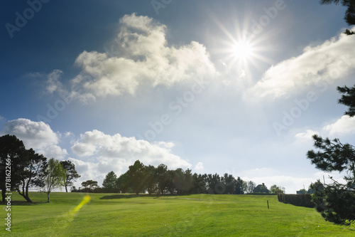 General view of a green golf course on a bright sunny day. Idyllic summer landscape. Sport, relax, recreation and leisure concept