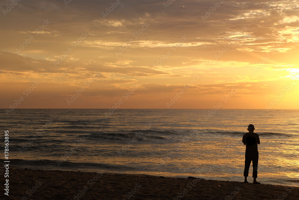 Silhouette of man at the sea at Cha-am Beach, thailand at the sunrise