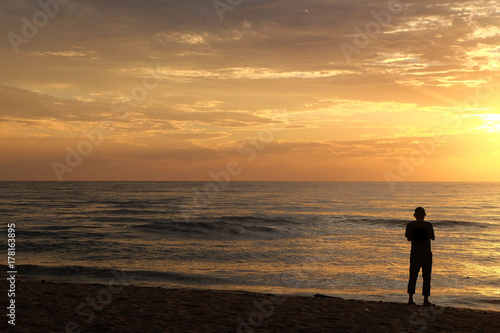 Silhouette of man at the sea at Cha-am Beach, thailand at the sunrise