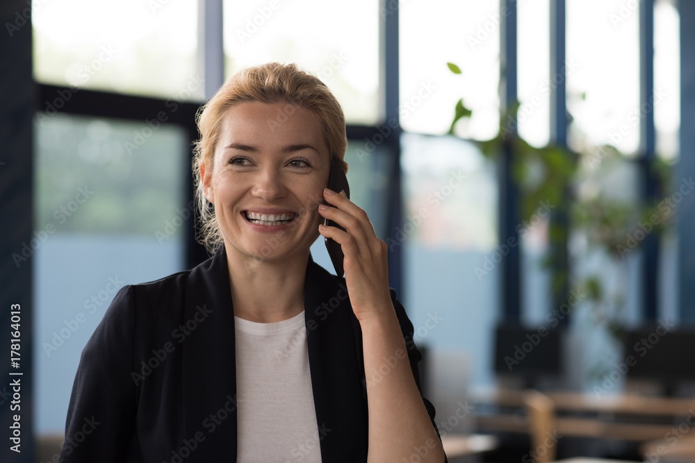 Smiling university student talking on mobile phone Smiling university student talking on mobile phone