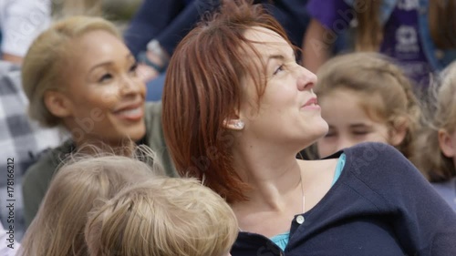  Families watching a demonstration at falconry center, focus on audience