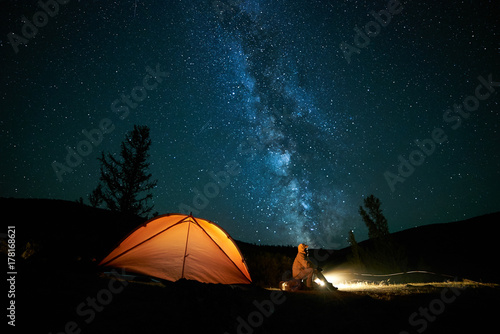 Tourist near his camp tent at night.
