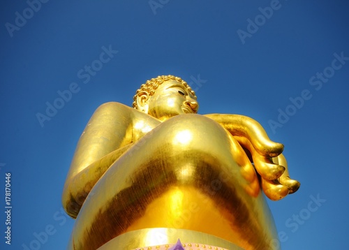 Золота статуя сидящего будды в Phra Chiang Saen Si Phaendin с необычных ракурсов