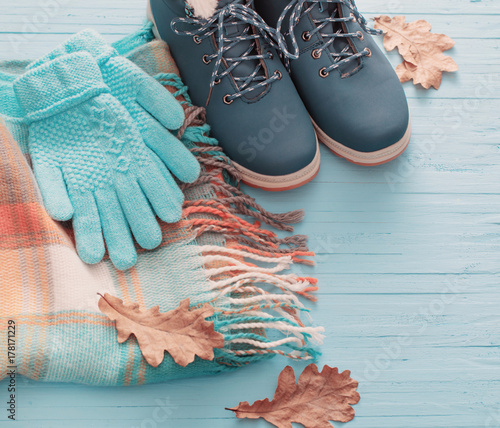blue winter shoes and gloves on blue wooden background