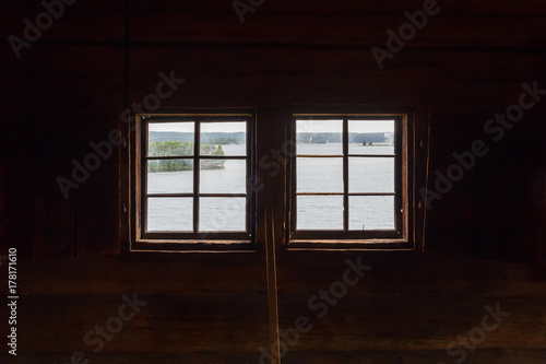 Two windows in a dark wooden church