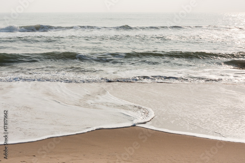 Foamy waves on calm beach - Foamy sea waves on a calm tropical beach in the morning.