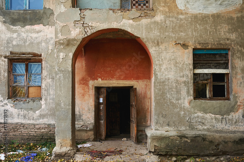 Fototapeta Naklejka Na Ścianę i Meble -  An old abandoned house with broken windows and cracks in the wall.