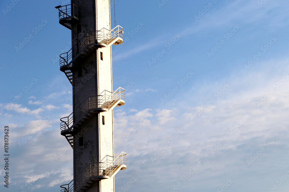 White tower with a spiral staircase against the blue sky White tower with a spiral staircase against the blue sky