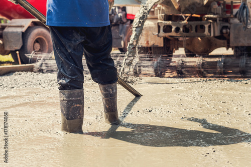 pouring concrete with worker mix cement at construction site