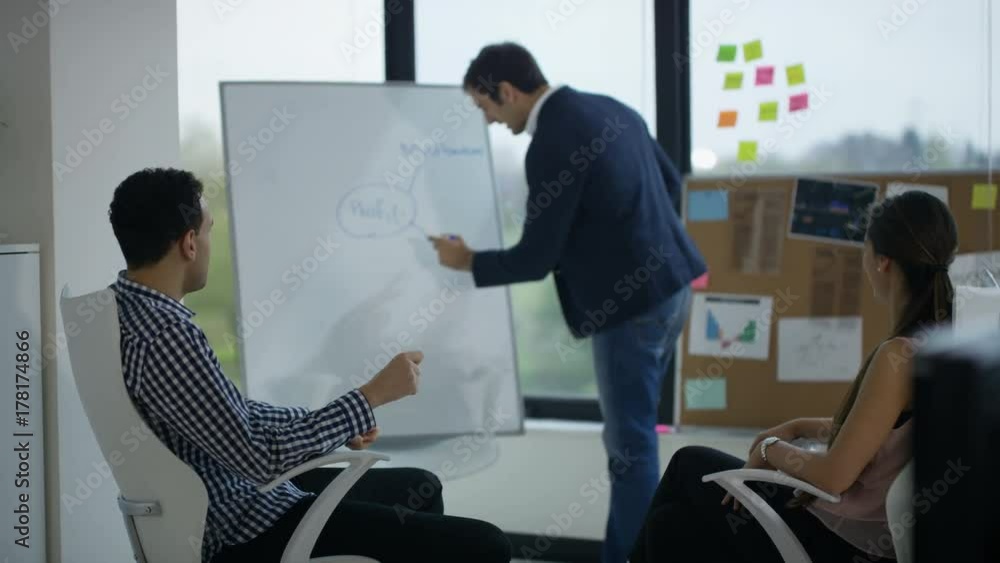 Portrait smiling businessman with tablet & colleagues working in background Portrait smiling businessman with tablet & colleagues working in background