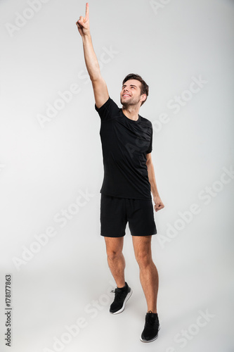 Ful llength portrait of a smiling young sportsman standing