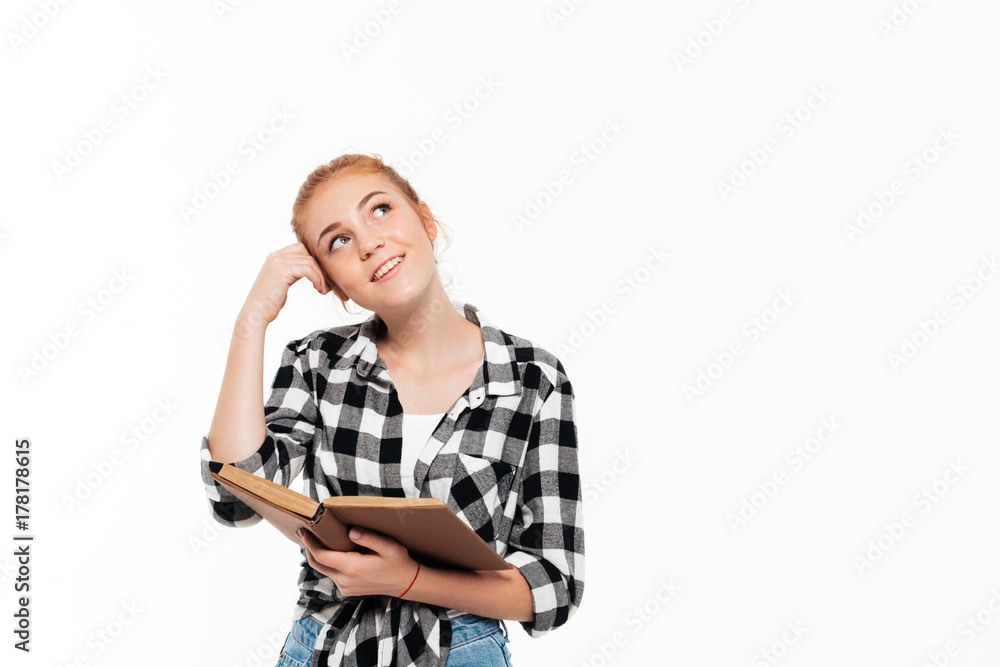 Smiling pensive ginger woman in shirt holding book Smiling pensive ginger woman in shirt holding book