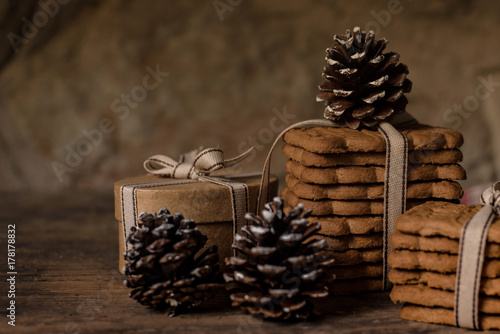 Christmas atmosphere with biscuits and pine cone on rustic background