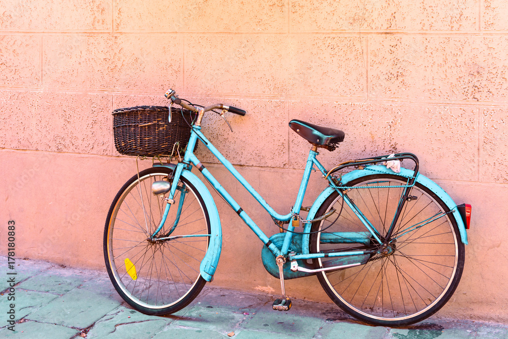 old turquoise bicycle with basket parked near the wall, vintage toned