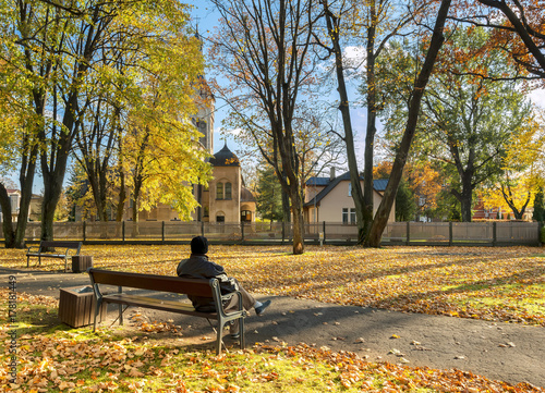 Resting senior in autumnal old city park, Europe