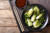 Stir Fry spicy baby bok choy close-up and a sweet chili sauce. horizontal top view