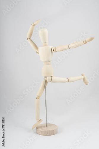 a wooden dummy posing while running 