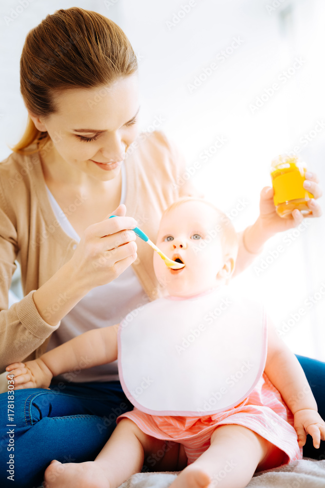 Caring mother feeding her hungry baby Caring mother feeding her hungry baby