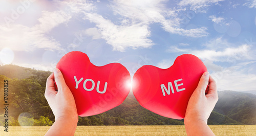 Hand hold couple red heart with text you and me on nature background photo