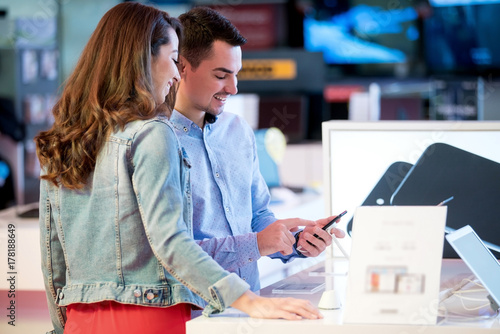 Couple shopping for latest laptop and smartphone