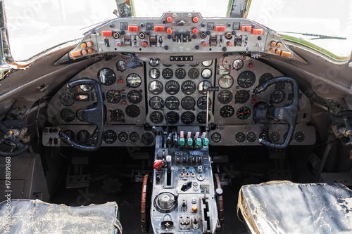 Old aircraft cockpit with steering wheels, control levers, and a