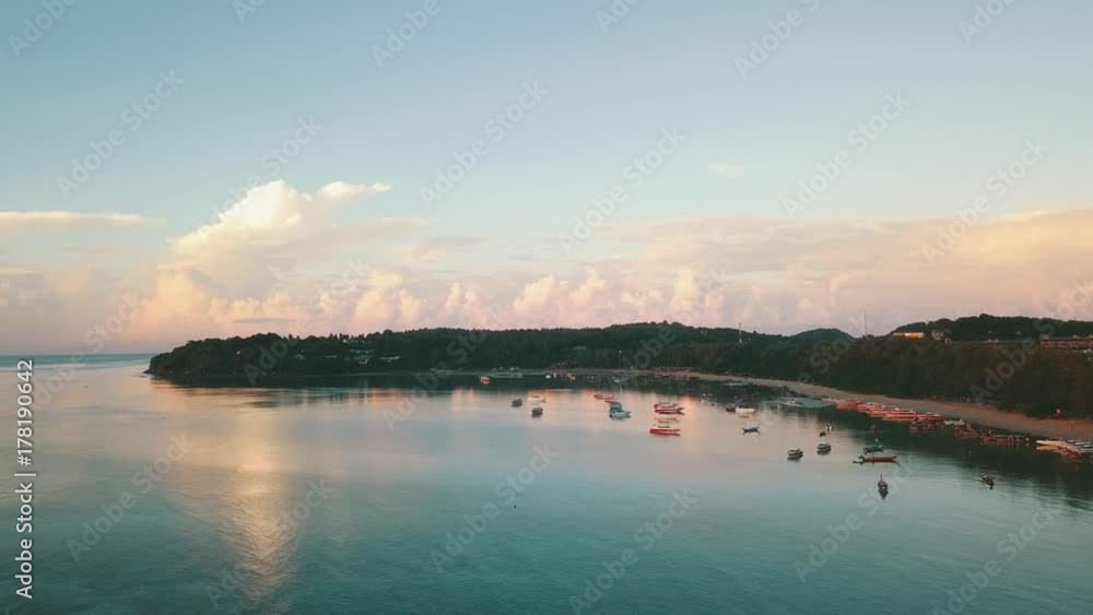 Sunrise bay in tropical island with reflected calm water and clouds aerial shot Sunrise bay in tropical island with reflected calm water and clouds aerial shot