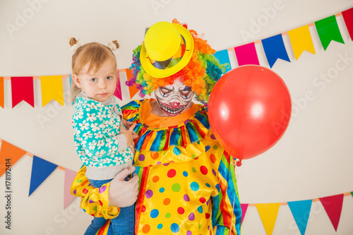 a terrible clown and a child. Halloween. The crazy clown. Childish fear
