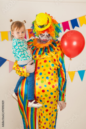 a terrible clown and a child. Halloween. The crazy clown. Childish fear