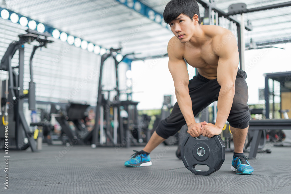 Fitness man warming and stretching in gym Fitness man warming and stretching in gym