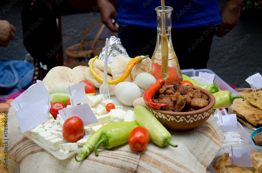 various delicious food on table for food street festival, cheese, tomato, peppers, cracklings and plastic forks